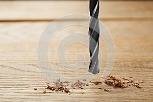 Metal drill bit make a holes in wooden oaks plank