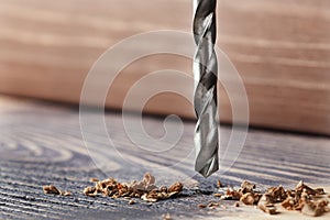 Metal drill bit make a holes in wooden oaks plank