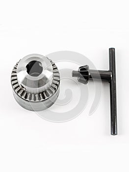 Metal drill chuck with a key on a white background