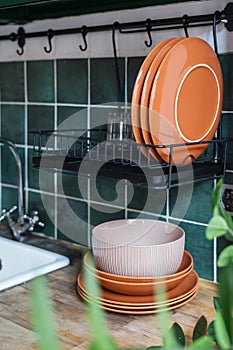 Metal drying rack with plates and glass in kitchen
