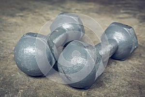Metal dumbbell on cement floor, fitness sport of bodybuilding