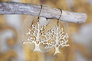 metal earrings in ornamental shape hanging on neutral background