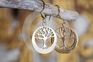 metal earrings in ornamental shape hanging on neutral background