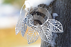 Metal earrings on outdoor natural background