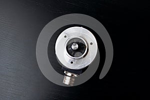 Metal encoder on a black wooden table