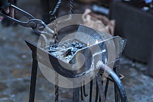 A metal fabricator utilizing a torch to heat up a piece of metal in order to shape it utilizing a forging technique