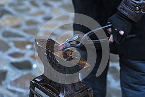 A metal fabricator utilizing a torch to heat up a piece of metal in order to shape it utilizing a forging technique