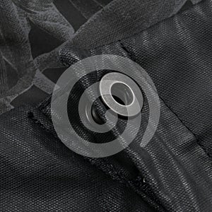 Metal fastener on avant-garde black waxed pants photo