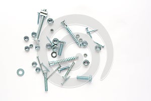 metal fasteners of different sizes and diameters: nails, bolts, nuts on a white background. view from above