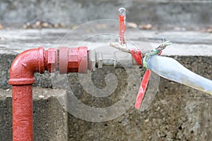 metal faucet and rubber tube that goes from red pipe