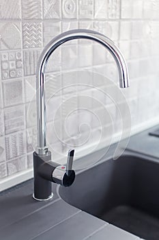 Metal faucet sink in modern kitchen. New home interior