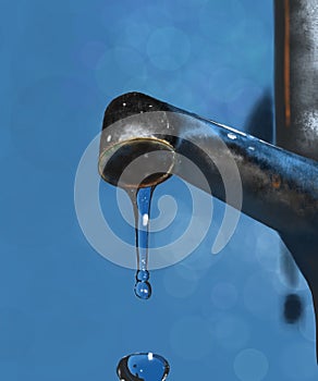 a metal faucet from which Blue drops of water flows