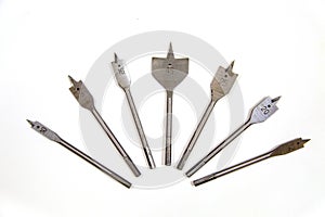 Metal feather drills of various diameters arranged in a fan isolated on a white background, a joiner`s construction