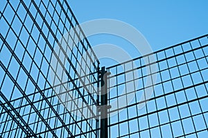 Metal fence on blue sky - metal grid construction