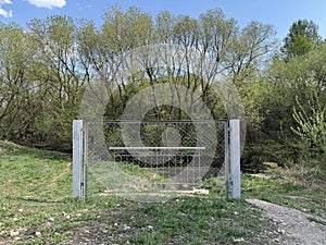 Metal Fence Gate Blocking Small Footbridge in Forested Area photo