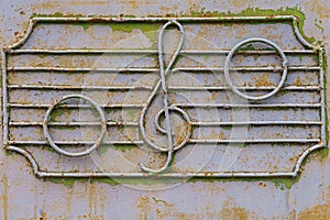 Metal fence of the old music school with decorative symbols in the form of a treble clef and notes on the stave