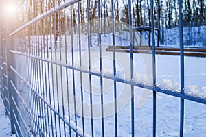 Metal fencing in a winter park. The use of sturdy metal netting for zoning the playground. photo