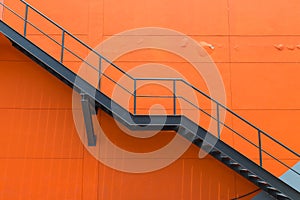 Metal fire escape or emergency exit on Orange Wall of Buliding