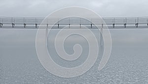 Metal foot bridge above the surface of the sea or ocean in cloudy overcast weather. Empty iron crosswalk on the calm water.
