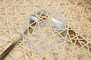 Metal fork and knife under a decorative mesh