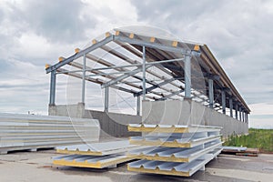 Metal frame of the building with a sandwich panel of insulation on the wall. Construction of a new industrial building. Modern