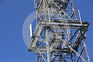 Metal frame of telecommunications tower in front of a dark blue sky