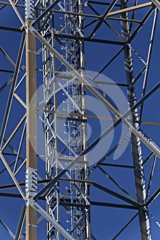 Metal frame of telecommunications tower in front of a dark blue sky