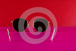 Metal Framed Sunglasses on a Pink Base and Red Background