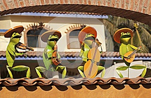 Metal frog mariachis on a roof photo