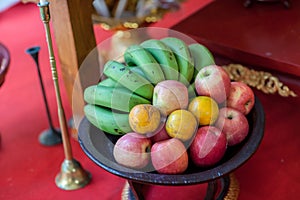 Metal fruit bowl on a wooden surface. Close. Bananas, oranges and apples. Mix of fresh apple,banana,orange, in a basket.