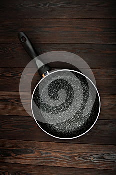 Metal frying pan: Ceramic coating with non-stick coating: Kitchen utensils On a wooden background: Cooking for chefs in the