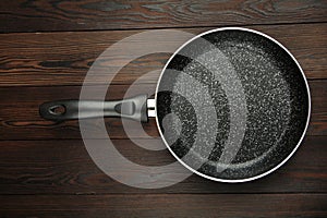 Metal frying pan: Ceramic coating with non-stick coating: Kitchen utensils On a wooden background: Cooking for chefs in the