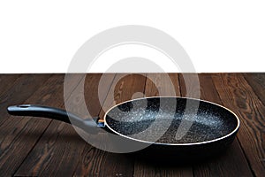 Metal frying pan: Ceramic coating with non-stick coating: Kitchen utensils On a wooden background: Cooking for chefs in the