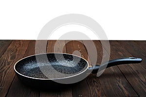 Metal frying pan: Ceramic coating with non-stick coating: Kitchen utensils On a wooden background: Cooking for chefs in the