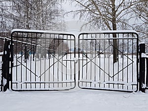 Metal gate covered with snow