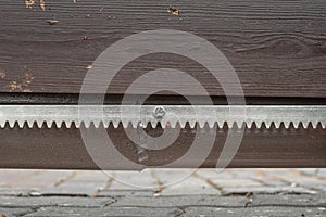 Metal gate rack toothed rail on wooden gate photo