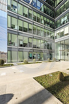 Metal and glass facade with hedged gardens at the entrance of an office building