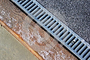 Metal grate of rainwater drainage system on a sidewalk