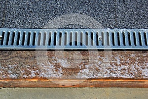 Metal grate of rainwater drainage system on a sidewalk