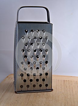 Metal grater on a wooden cutting board