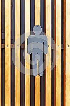 Metal gray men\'s room icon on wooden slatted wall. Identification of the rest room. Front view. Close-up