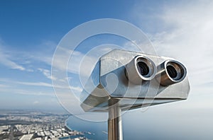 Metal grey coin operated telescope isolated at beautiful summer panoramic view at cityscape