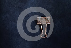 metal grunge paper clip on black leather background