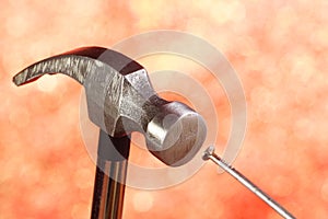 A metal hammer hammers a nail.