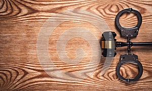 Metal handcuffs and judge gavel on wooden background. Crime and Law Concept