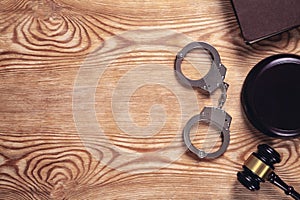 Metal handcuffs and judge gavel on wooden background. Crime and Law Concept