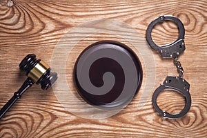 Metal handcuffs and judge gavel on wooden background. Crime and Law Concept