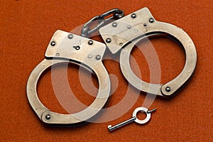 Metal Handcuffs on OrangeBackground