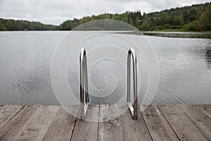 Metal handrail for descent into the lake, iron ladder for swimmers