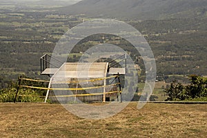 Metal hang gliding ramp overlooking a valley.